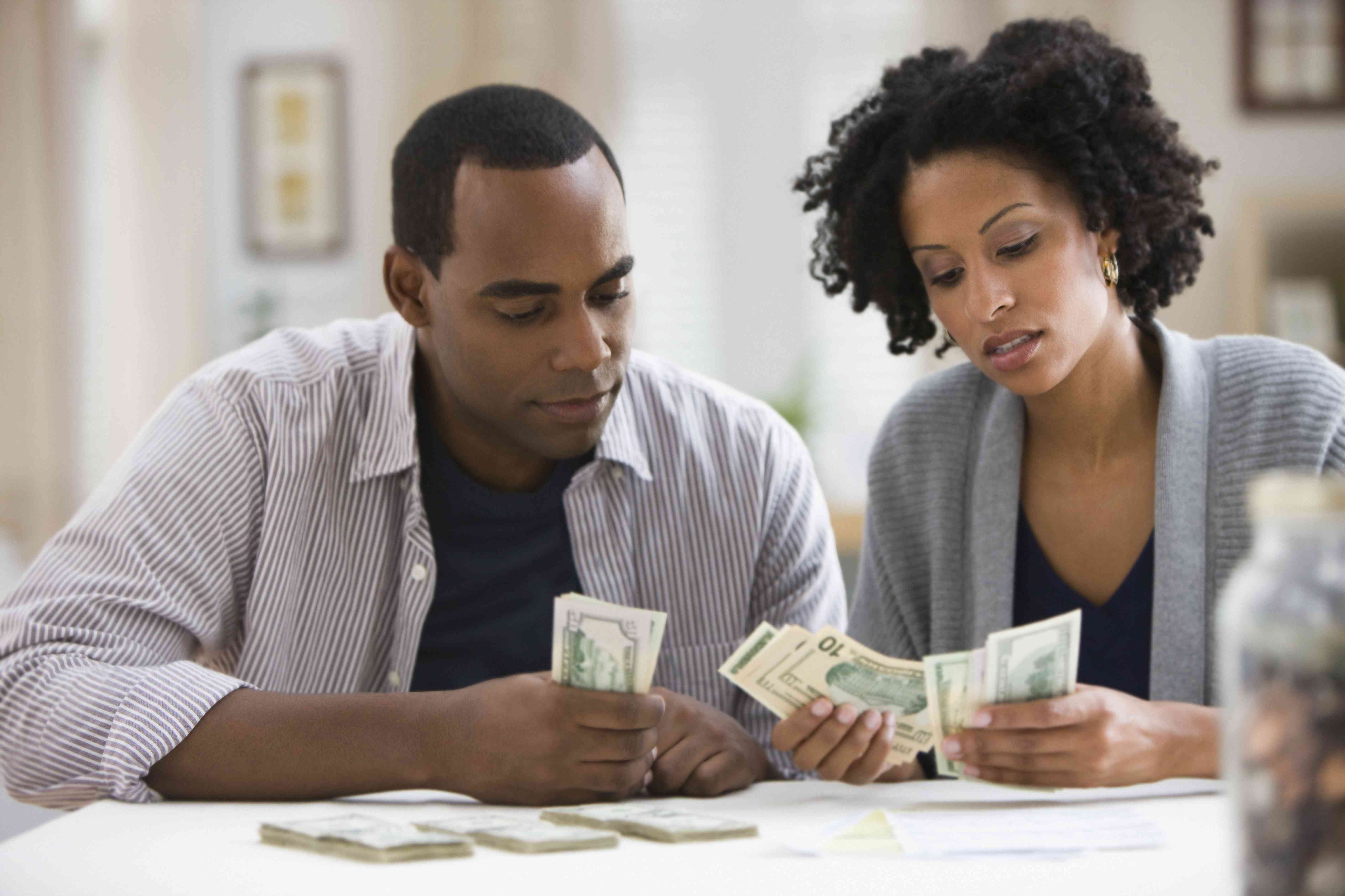 Man and woman count cash on their counter