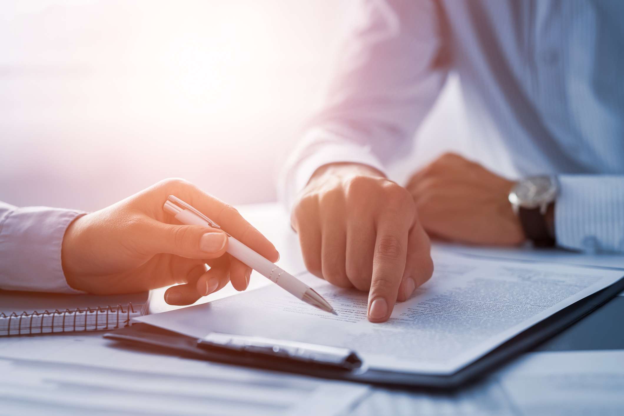 Two people signing a contract