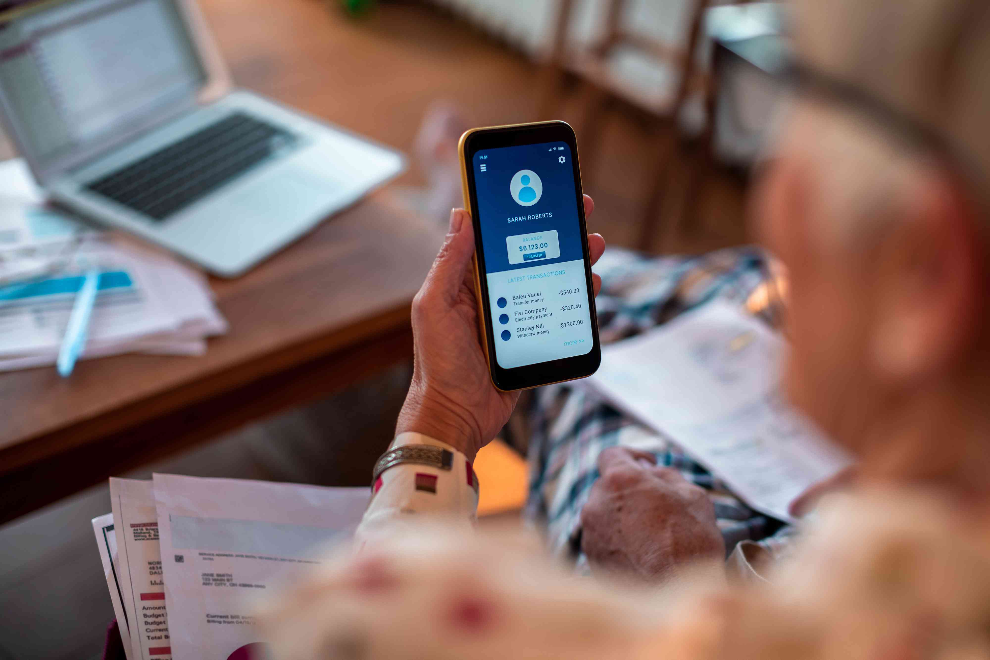 Senior woman using online banking on her phone to look at her savings account