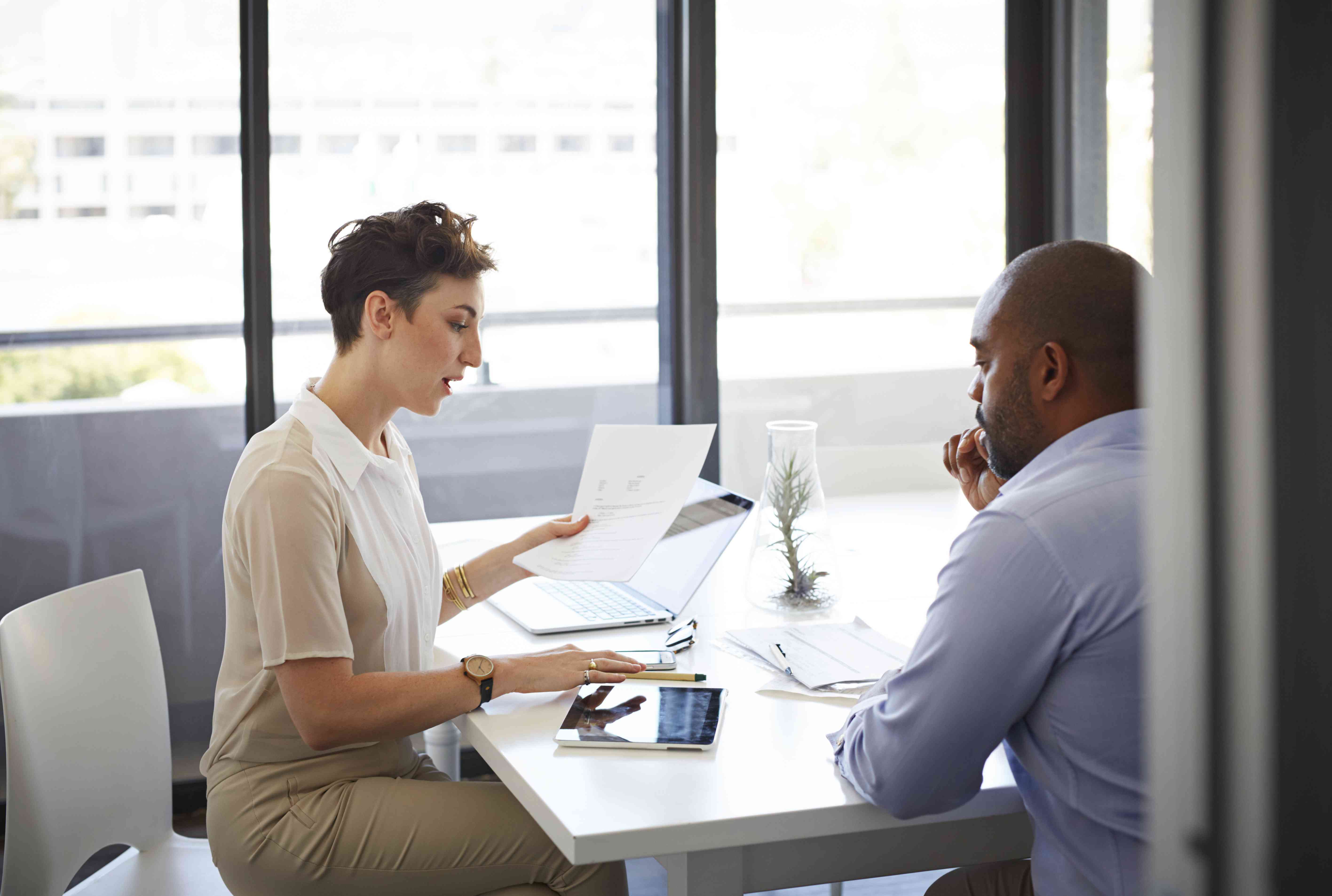 Two business colleagues sitting down discussing paperwork