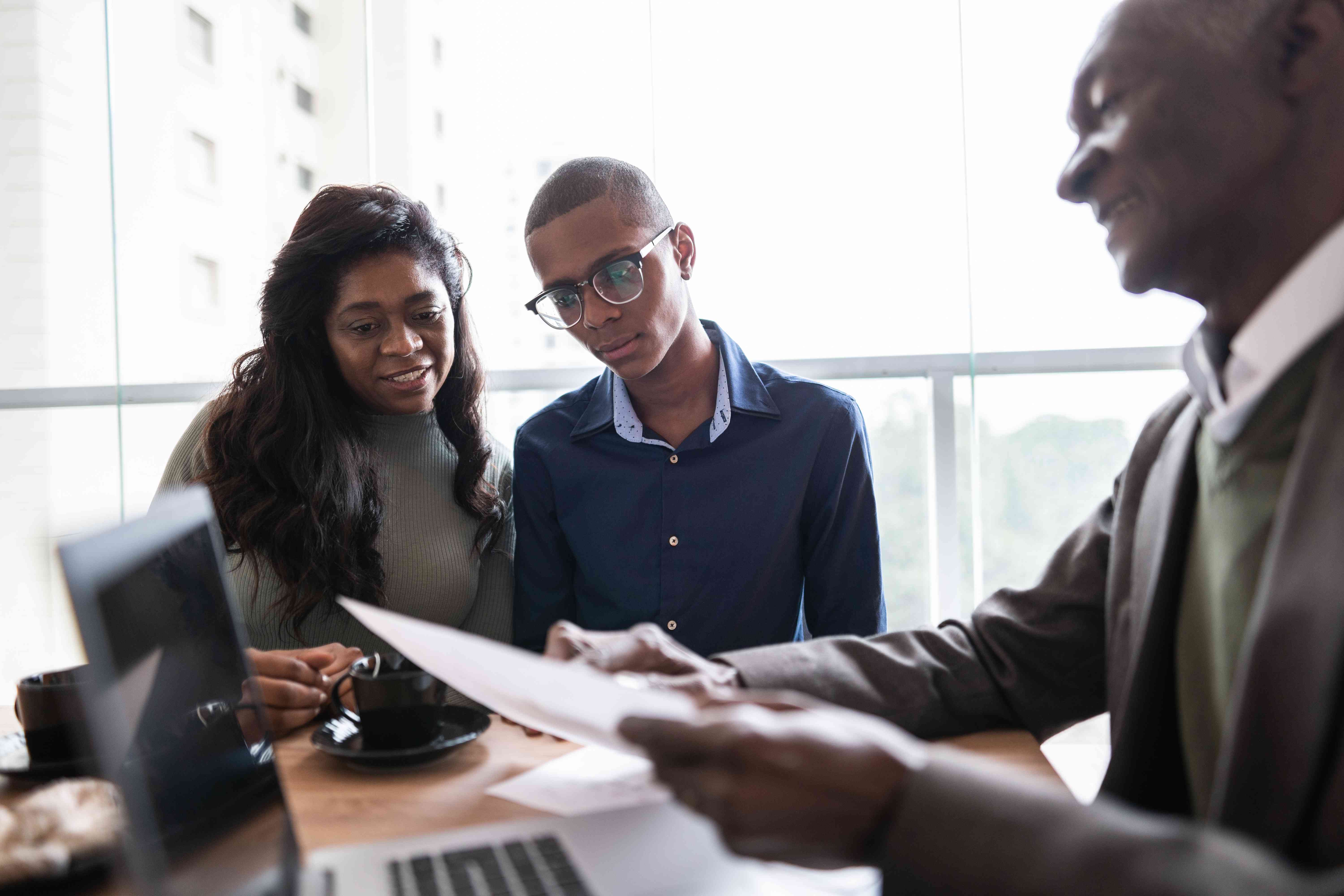 Investment advisor in an office giving two potential investors information about bond funds