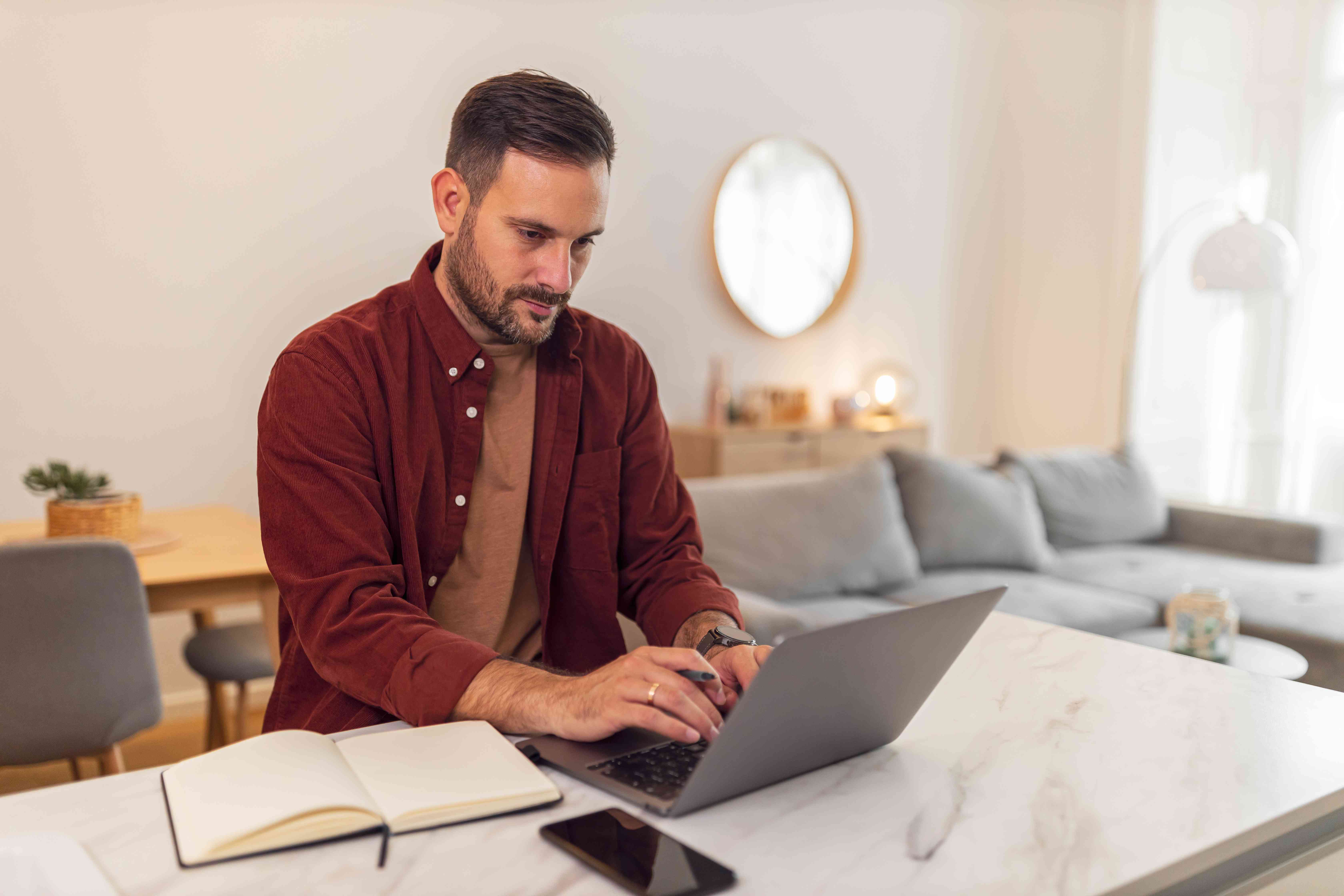 Young man doing his research on his laptop at home